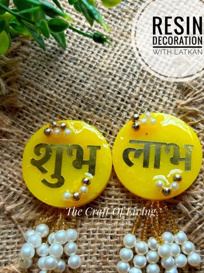 Add a sparkle to your celebrations with these resin Shubh Labh decorations with latkan. The bright yellow and pearl details make them a cheerful addition to your festive decor.