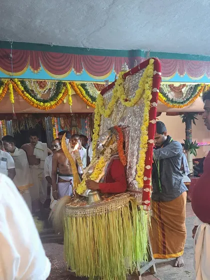 Phase 3 of the Dhumavati Kola, where the performer is fully adorned with a large silver mask and chest plate, holding a sword and bell.