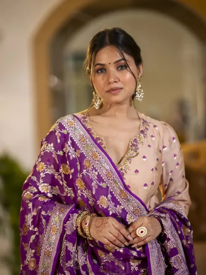An intimate portrait that draws attention to the intricate embroidery on the neckline and the rich texture of the dupatta. This close-up view allows customers to appreciate the craftsmanship.
