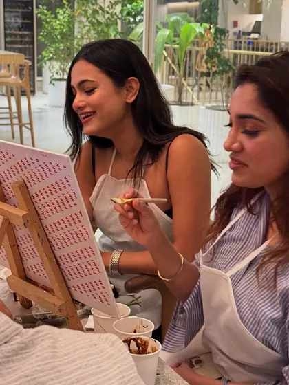Two friends enjoying our coffee painting workshop. It's a unique and fun activity to try with a friend, combining a love for coffee and art.