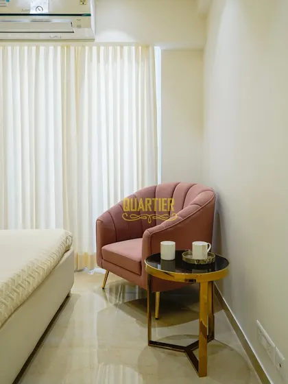 Every corner is an opportunity for design. In this bedroom, I created a cozy reading nook with a plush pink armchair and a small side table, providing a perfect spot to unwind with a cup of coffee and a book.