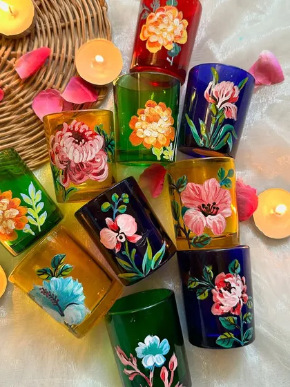 A top down view of our beautiful, hand painted floral candle holders, surrounded by tea lights and flower petals. They are available exclusively on our website.