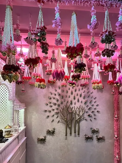 We created a breathtaking ceiling with hundreds of hanging floral strings (latkans) in shades of pink and white, transforming the room into a fragrant, festive canopy for a wedding celebration at home.