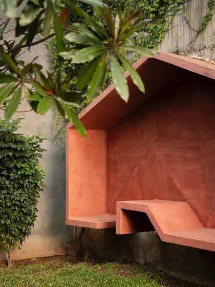 A view of the sculptural wall seating, showing how it is integrated into the landscape. The piece provides a functional nook for one or two people, turning an unused corner into a destination.
