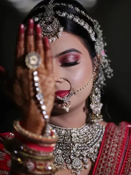 The details make the look. This artistic shot highlights the intricate eye makeup, the beautiful nath (nose ring), and the detailed hathphool (hand jewelry), all essential elements of a traditional bridal look.