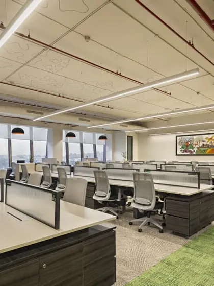 Another perspective of the open work hall at the Carlsberg office. The design features an exposed ceiling with visible ductwork, contributing to a modern, industrial feel, while organized workstations ensure a productive environment.