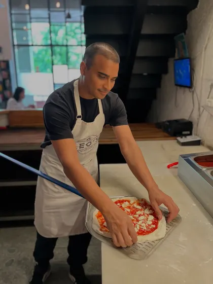 Getting a Margherita ready for its journey into the fire. The careful placement of cheese ensures a perfect melt.