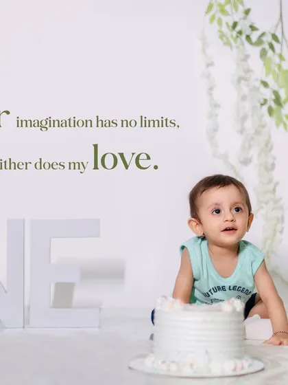A quiet moment during a first birthday cake smash session. This minimalist studio setup with soft green accents puts all the focus on the little one's curious expression.