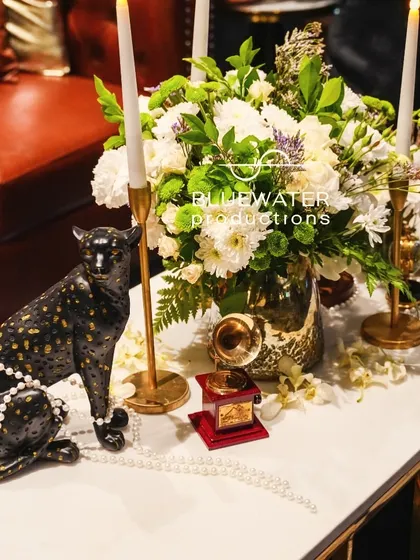 A detail that tells a story. For a vintage glam Sangeet, a black panther statue draped in pearls sits next to a miniature gramophone and fresh white flowers.