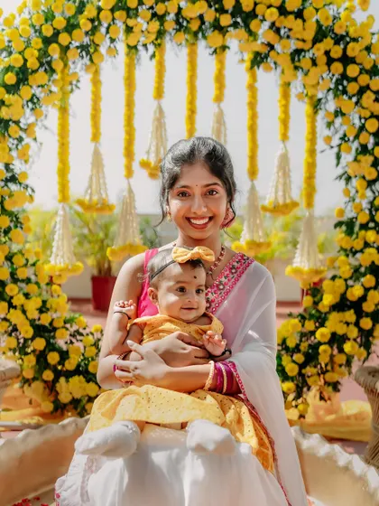 A mother and her baby enjoy the beautiful Haldi decor, showing that our designs create a welcoming space for all guests.