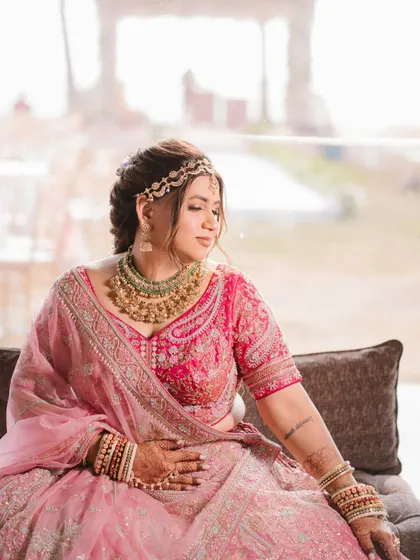 A close-up bridal portrait by a window, using soft natural light to highlight her features and jewelry.