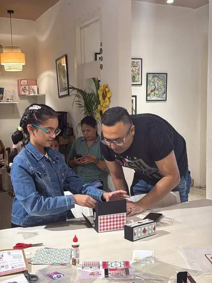A father and daughter working together on a paper craft project. It's wonderful to see families collaborating and sharing a creative moment in the studio.