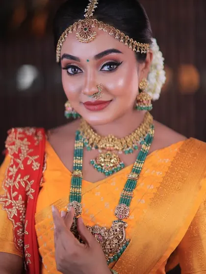 A close-up of a festive look. The bright yellow saree with a contrasting red pallu is perfect for any celebration, and the drape is kept neat to highlight the beautiful colours.