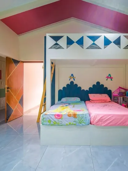 A view of the bunk bed setup, with personalized headboards and playful geometric patterns, designed to maximize space in a shared children's room.
