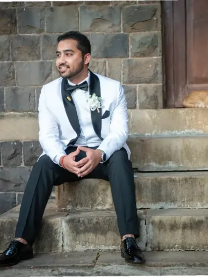 Even the local residents want to be in the shot. A fun, candid portrait of the groom with an unexpected feline friend at the church steps.