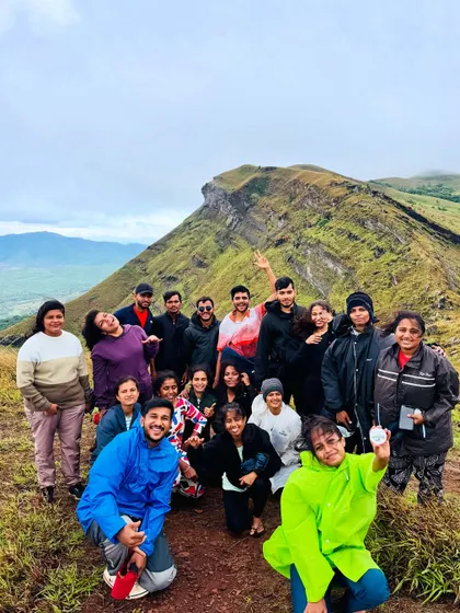 A group photo on the trail in Chikmagalur, with one of the region's unique peaks in the background.