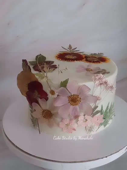 This cake is a true work of art, adorned with hand-pressed, natural dried flowers. Each flower was carefully preserved and placed to create this stunning, delicate design on a no-fondant cake.