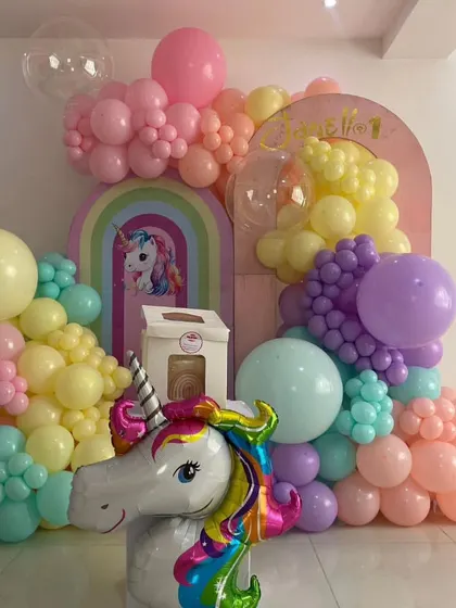 A whimsical pastel unicorn birthday setup. This decoration features a large unicorn head balloon, multiple arched backdrops, and a soft, dreamy color palette.
