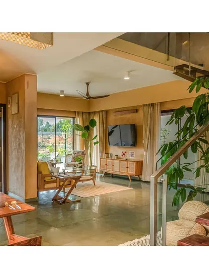 The open-plan layout allows for easy circulation and visual connection between the dining area, living room, and staircase.
