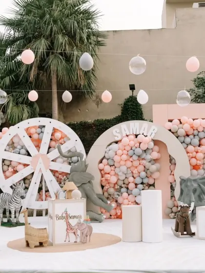 The main decor setup for the pastel jungle party, with a custom name sign, a giant wheel backdrop, and an array of cute animal figures.