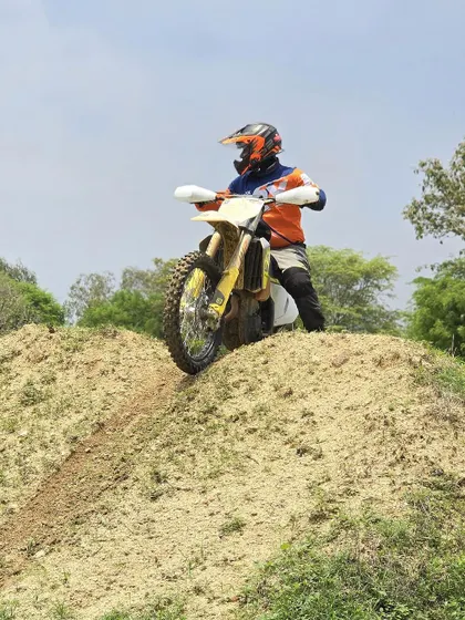 A rider on a Husqvarna dirt bike, ready to take on the next challenge. Our training isn't limited to one type of bike; we help you master the machine you bring.