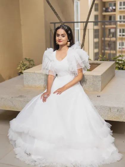 An angelic vision in white. This layered tulle gown with its whimsical ruffled sleeves is perfect for creating a soft, romantic, and dreamy look.