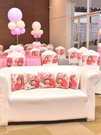 The entire hall was transformed for this pastel-themed event. I provided themed chair covers, matching cushions for the sofa, and balloon centerpieces for each table.