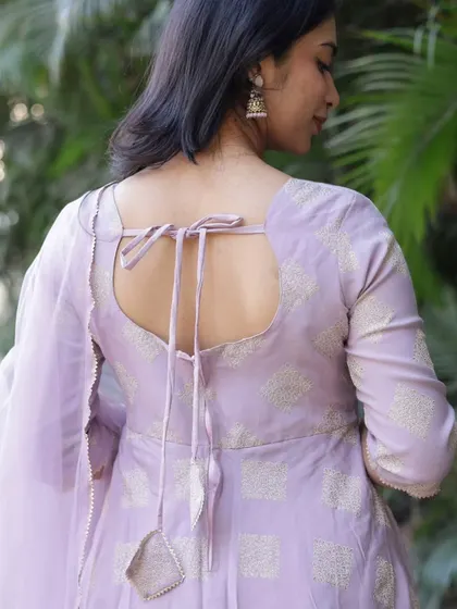 A shot from the back, focusing on the elegant tie-up detail and the delicate fabric of the lavender Anarkali.