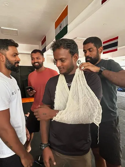 Team members practicing how to properly apply an arm sling.