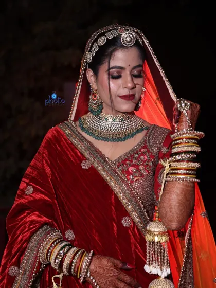 A beautiful three-quarter length bridal portrait showcasing the bride's complete look, from her jewelry and veil to her embroidered lehenga.