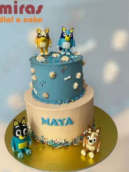 Hooray! This two-tier Bluey cake is ready for a party. Featuring Bluey, Bingo, and their family, this cake is decorated with colorful sprinkles and character toppers, capturing the fun and playful spirit of the show.