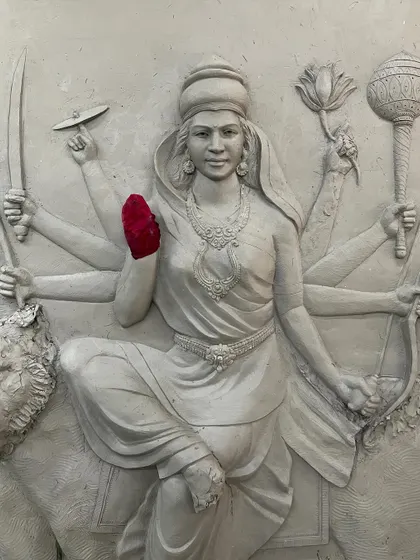 A detailed view of the Maa Durga clay sculpture, focusing on her face and upper body. This stage is crucial for capturing the divine essence of the deity.