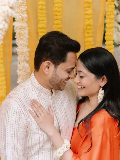 A happy, sun-kissed portrait of the couple during a pre-wedding function, their smiles reflecting the joy of the occasion.