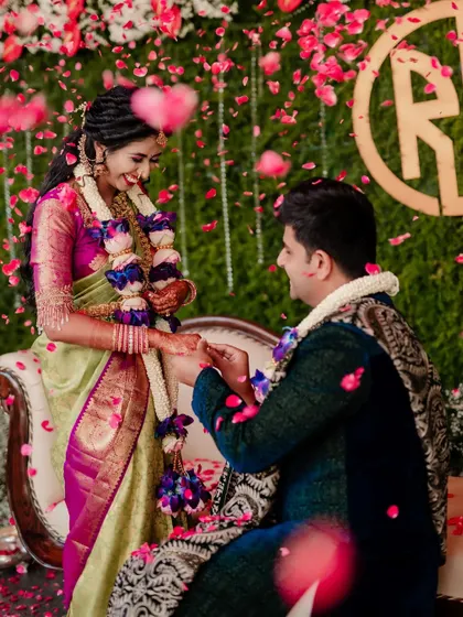 A moment of pure joy during the ring exchange ceremony, with flower petals showering the happy couple. These are the moments that define a celebration.