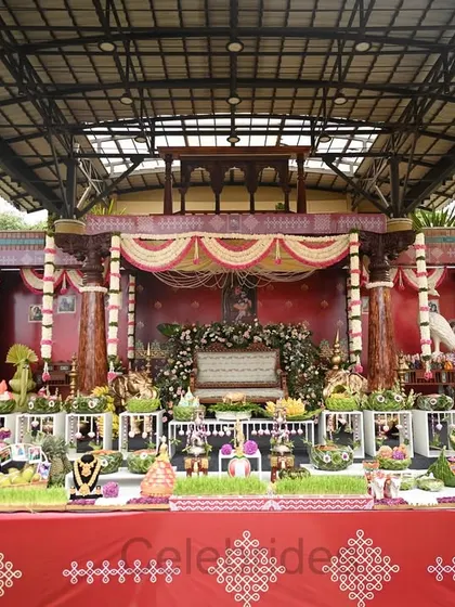 A grand and elaborate setup for a baby shower, featuring a wide stage filled with traditional dolls and offerings (aarathi thattu).