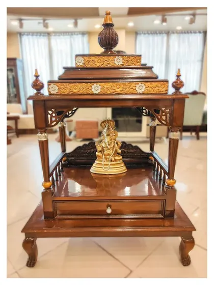This handcrafted pooja mandir is made from solid teak wood with a rich walnut finish. The design features traditional carving details and a tiered shikhara, creating a serene and sacred space in your home. I can customize the size and details to fit your specific needs and traditions.