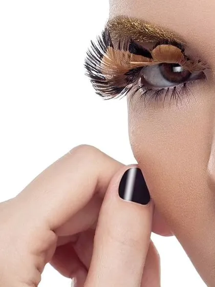 A detailed close-up of the creative makeup look, focusing on the feather eyelash and the perfectly manicured nail. This type of shot is crucial for showcasing the work of a makeup artist.