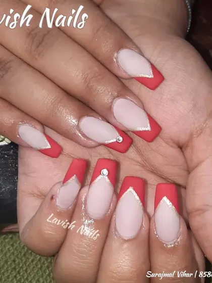 A dramatic, deep-V French manicure in a bold red color on long coffin nails, accented with silver lines and a single rhinestone.