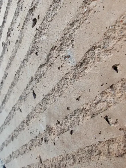 The rough, honest texture of a poured earth wall, showcasing the beauty of the material's imperfections.