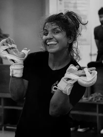 A candid shot of Priya Sharma. A warrior in the cage and a jovial person outside of it.