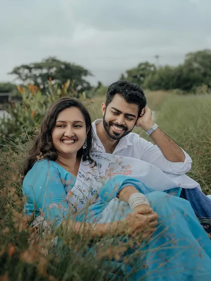 A relaxed and happy moment with a couple sitting in the grass by the water.