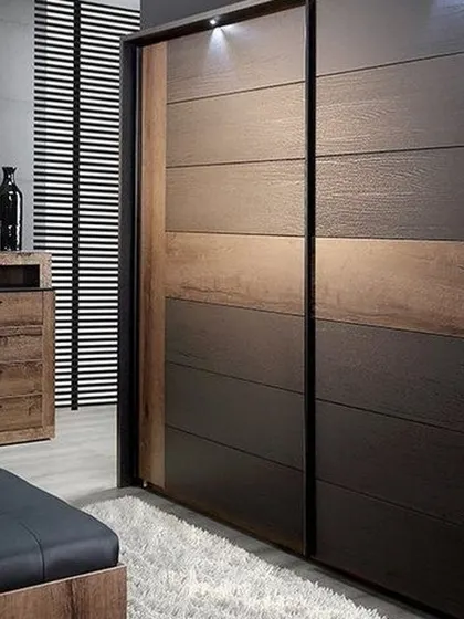 A modern sliding door wardrobe with a dual-tone wood finish, offering a space-saving solution for contemporary bedrooms.