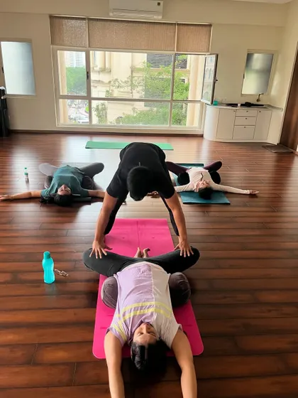 Helping a student find the right alignment in Baddha Konasana (Bound Angle Pose) to gently open the hips.