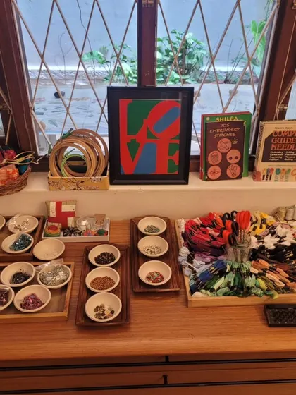A beautiful array of threads, beads, and fabrics set out for our community sewing circle. Preparing the materials with care and beauty is a mark of respect for the work and the people doing it.