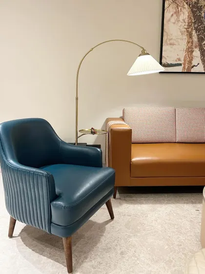 We love adding pops of color with our furniture. Here, a custom-made accent chair in rich blue leather with pleated detailing stands out against a tan leather sofa, adding personality to the room.