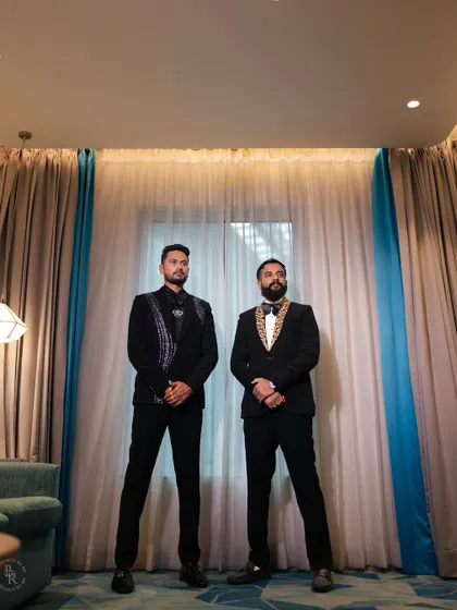 The groom and his groomsman looking sharp in their suits, ready for the reception.