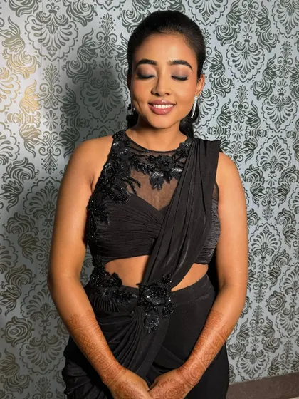 A chic and modern sangeet look for Deepa. The soft smokey eye and nude lip perfectly complement her stylish black cutout saree.