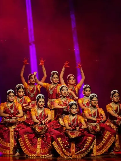 A seated formation from 'DURGE', where the dancers hold small drums. This pose demonstrates the versatility in our choreography, using different levels and props to create visual interest and rhythmic possibilities.