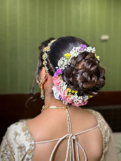 A detailed shot of the intricate floral bun, a perfect complement to her elegant outfit.