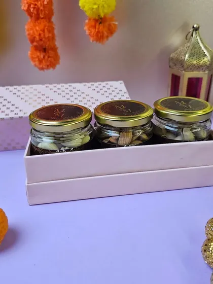 A minimalist yet elegant Diwali gift set. This includes three jars of assorted dry fruits and nuts in a sleek pink box, ideal for corporate or personal gifting.